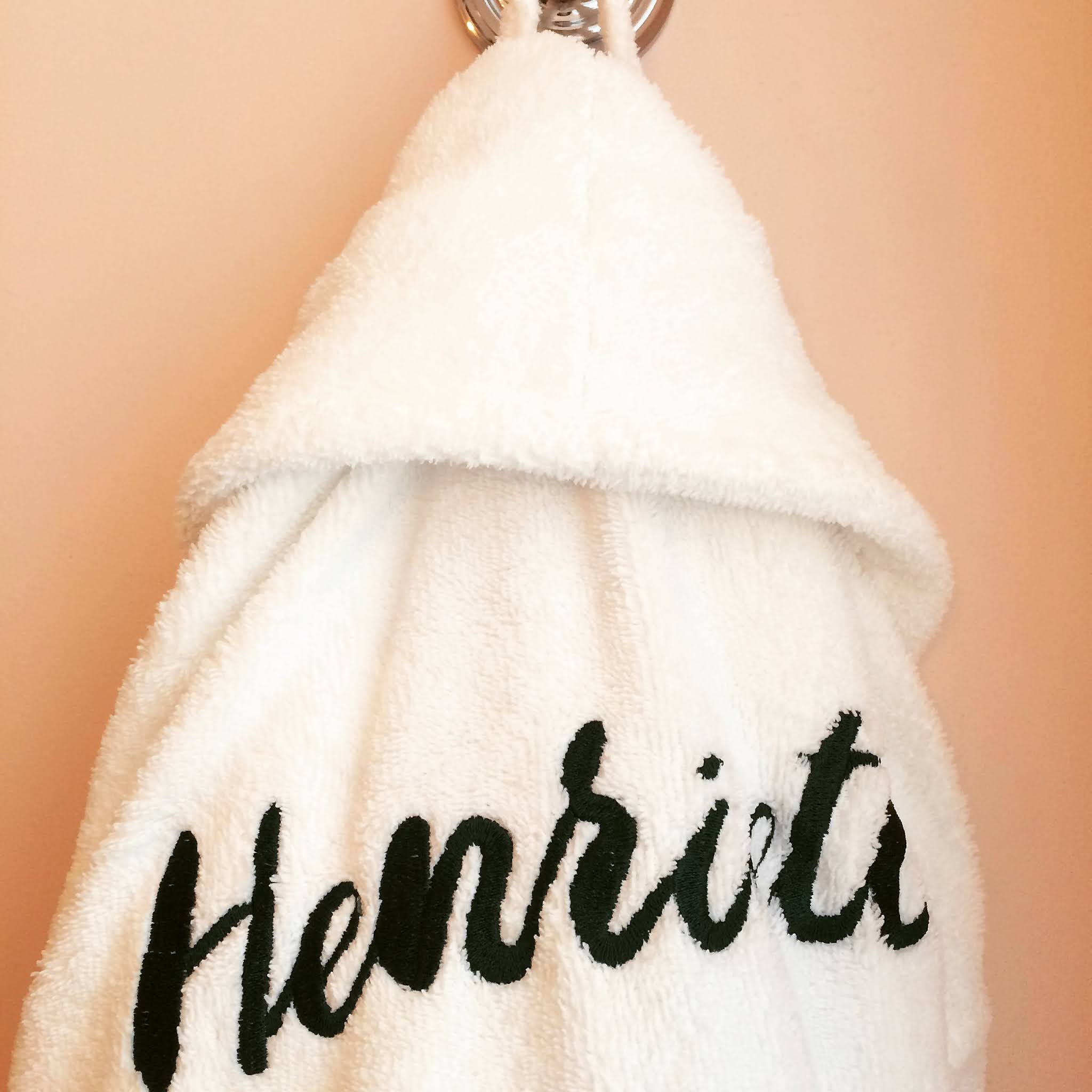 henrietta hotel bathrobe hanging against peach coloured wall