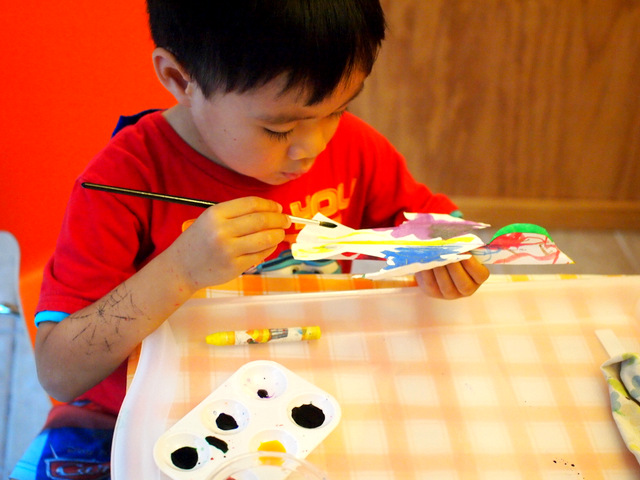 Preschool boy painting paper plate bird craft