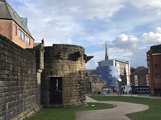 A view of Durham tower, an old stone tower that makes up part of the wall.  It has a barred gate and there are some stone structures sticking out along the roof.  Photo by Kevin Nosferatu for the Skulferatu Project.