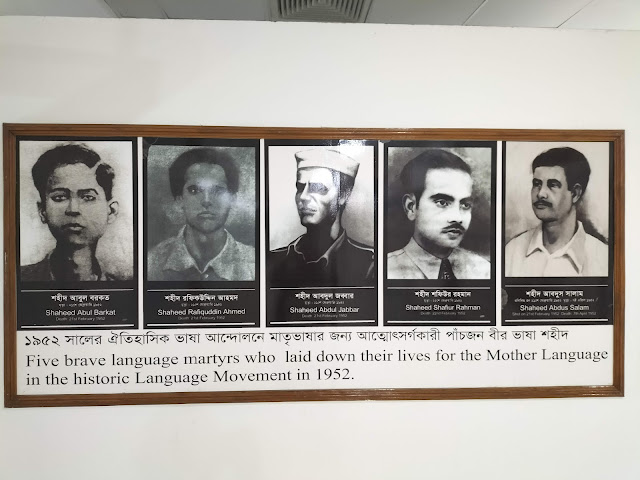 Sign with images of five men in black and white reading "Five brave language martyrs who laid down their lives for the Mother Language in the historic Language Movement in 1952".