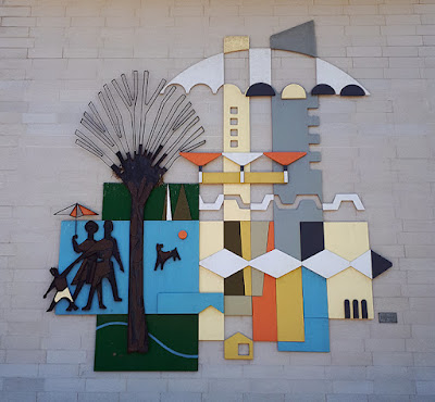 Flat ceramic mural featuring abstract architectural shapes, plus a family grouping with dog standing by a tree