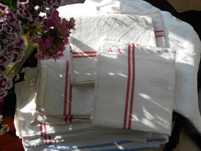 Aphoto of cream ivntage linen tea towels with a red stripe.