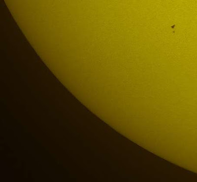 NASA's space shuttle Atlantis and the Hubble Space Telescope silhouetted against the Sun