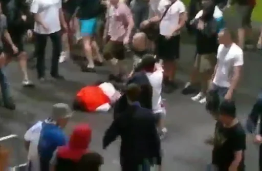 A stadium steward lies on the ground after being brutally attacked by Russian supporters