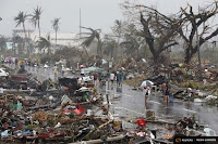 Residents walk on a road littered with debris after Super Typhoon Haiyan battered Tacloban city in central Philippines Nov. 10, 2013. (Credit: Reuters)  Click to Enlarge.