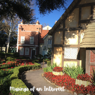 One of the buildings in Epcot UK with a winding side path lined with hedges and flowers