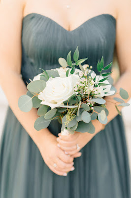 bridesmaid with blue dress holding flowers