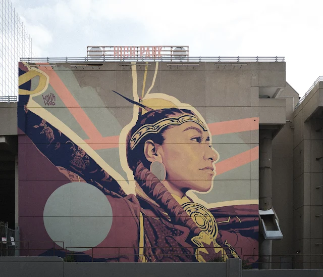 A mural of an Indigenous dancer on a concrete wall