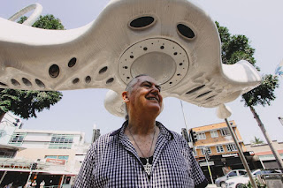 Luke standing beneath one of his sculptures in Brisbane