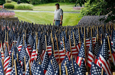 Michael Labbe stood beside the field of flags he and his family have planted in front of their home to honor all of those who have died from COVID-19 in Massachusetts.JESSICA RINALDI/GLOBE STAFF