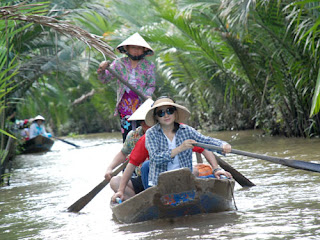 Rowing sampan on Mekong river canal