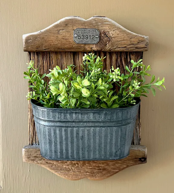 Photo of a repurposed, rustic wall pocket planter.