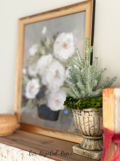romantic decor and art on vintage shelf with urn and faux greens