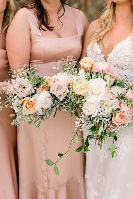 bride with bridesmaid in pink dress holding white and pink floral bouquet