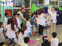 FOTO 8: SEÑO ALICIA DE SÉPTIMO GRADO REALIZANDO EL SORTEO DE LOS HUEVOS DE PASCUA, JUNTO A LA DIRECTORA Y A LA SEÑO Y ALUMNOS DE PRIMER GRADO