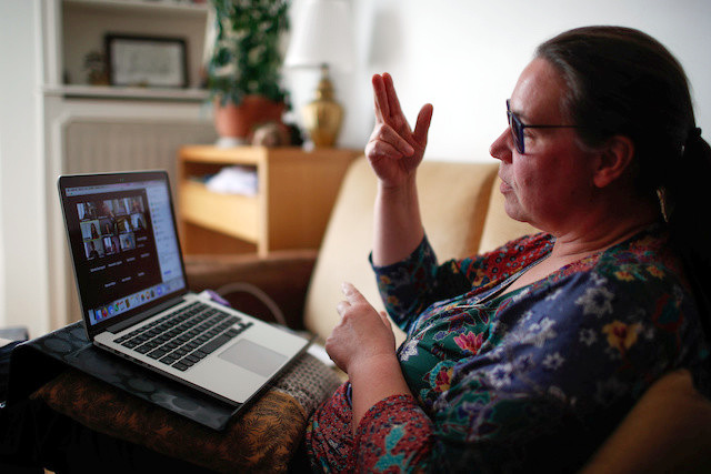 Professora em casa com computador em aula online