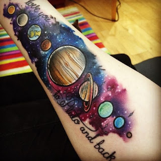 Tatuaje del universo a color en el antebrazo