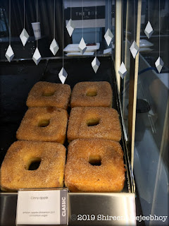 A tray of Cinny Apple square doughnuts in their case. 