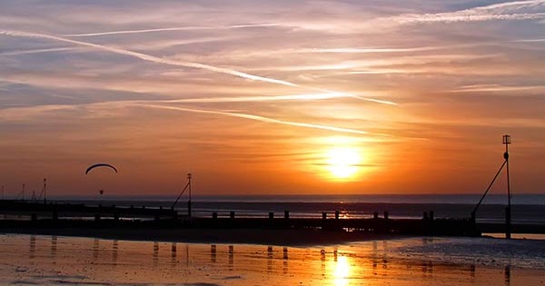 Pemandangan Matahari Terbenam di Tepi Pantai Gambar 