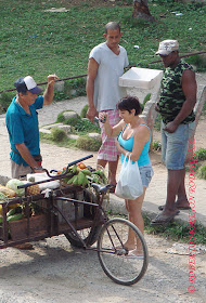Una mujer compra comida en una carretilla de un cuenta-propista en La Habana, Cuba.