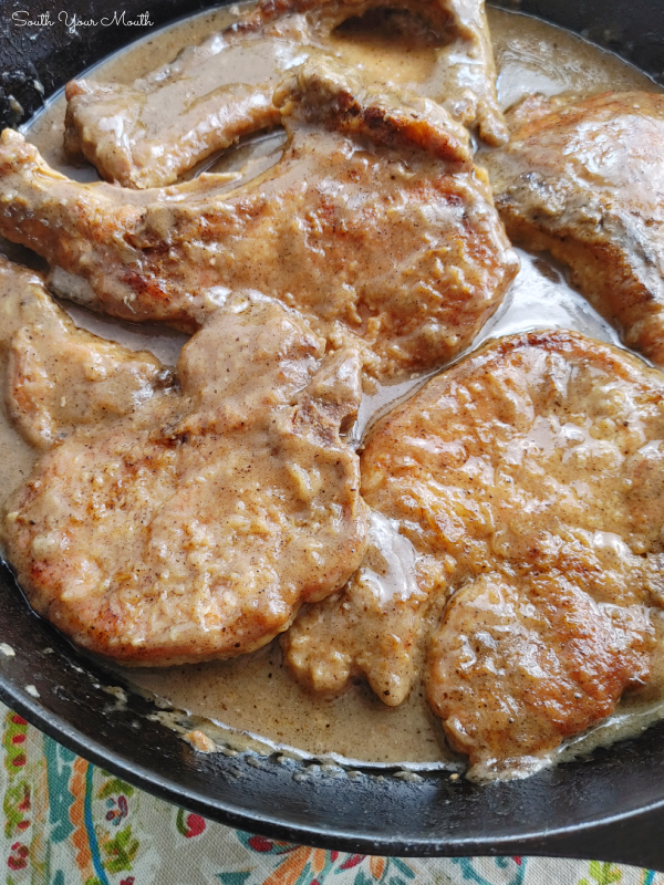 Smothered Pork Chops! A simple one-pan recipe for fork-tender pork chops smothered in gravy that thickens as the chops bake and tenderizes them low and slow in the oven.