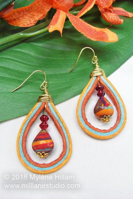 Teardrop earrings made with orange, turquoise and rust suede lace with a marbled bead dangle.