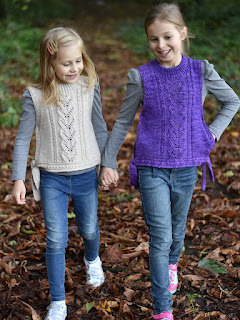 Two girls are modelling in matching knitted vests