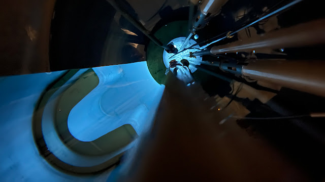 The inside of a nuclear reactor. There is blue light emanating from the center.