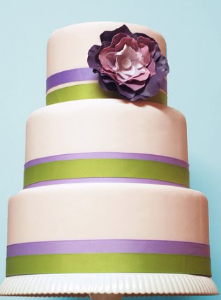 Three tier white wedding cake with lilac flowers and lime green roses 