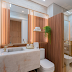 Banheiro com cara de lavabo decorado com madeira ripada, ônix e metalon dourado!