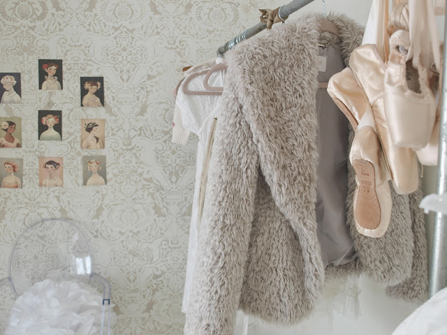 Stenciled Fortuny wall in feminine dressing room with ghost chair and garment rack