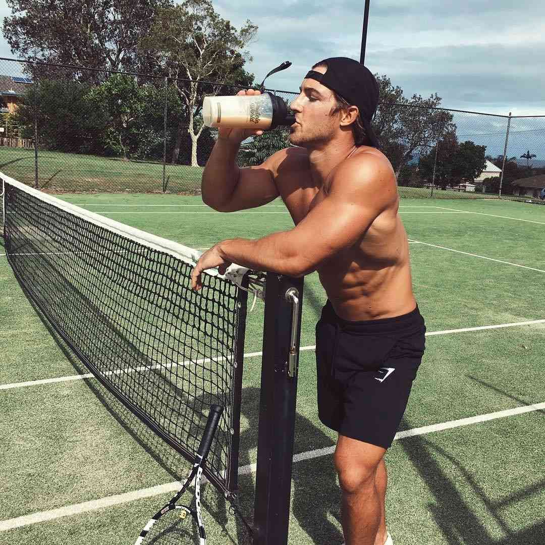 handsome-masculine-guy-shirtless-tennis-player-drinking