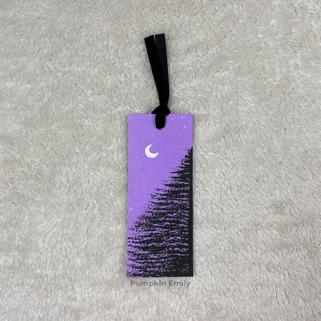 Purple bookmark with a painted tree, moon, and stars.