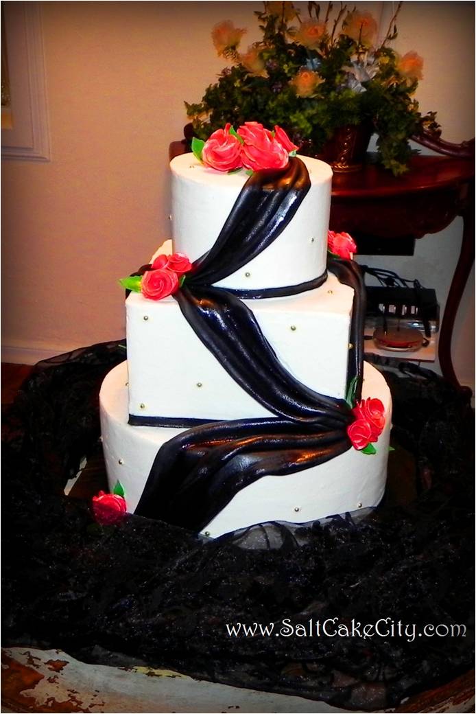 wedding cake with black marshmallow fondant draping red sugar roses