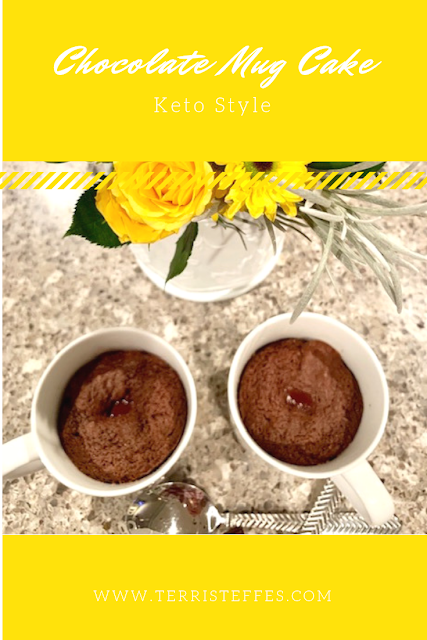 Chocolate mug cake with a bouquet of yellow flowers.