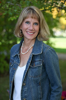 Photo of a blonde middle-aged woman outside smiling at the camera.