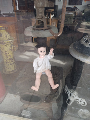 A creepy doll waving from a window