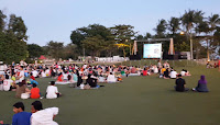 Photograph: the movie screen and the artificial grass field at Plawan Green, Sentosa