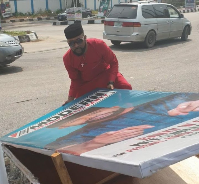 Banky W Seen Picking Up His Fallen Campaign Board 