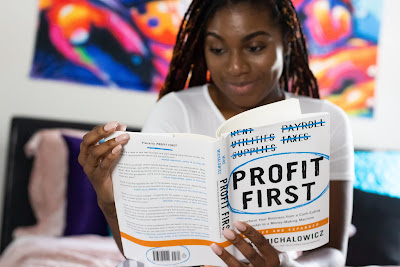 Woman reading Profit First - Photo by Natasha Hall via Unsplash: https://unsplash.com/photos/o8KUqjk9gqE