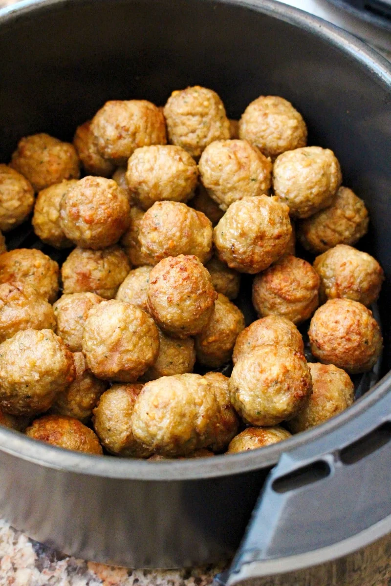 Air-fried meatballs in an air fryer basket.