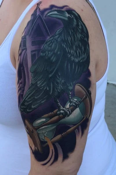Vemos un tatuaje de reloj de arena agarrado por un cuervo negro