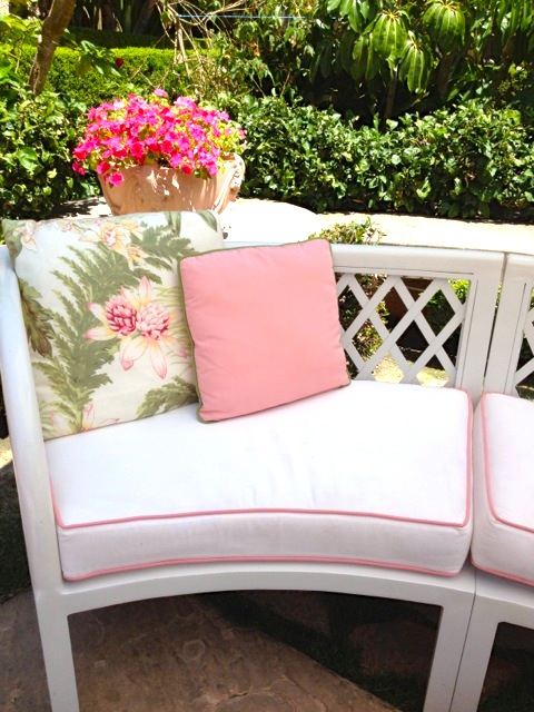 White curved sofa with pink pimping and decorative floral pillows