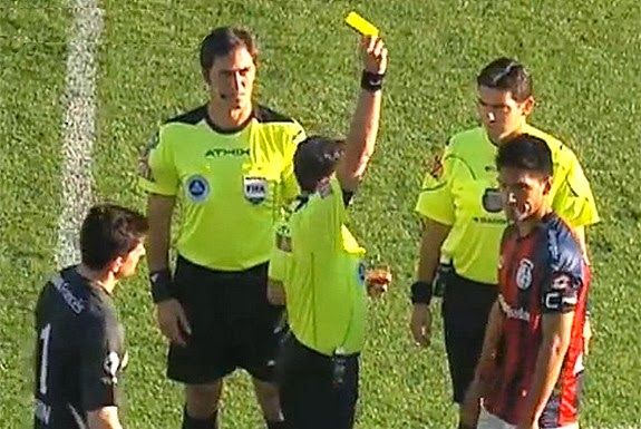 Referee shows the yellow card to San Lorenzo captain Pablo Alvarado before the game even started