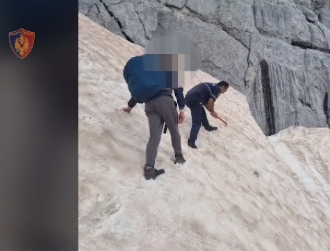 An Albanian policeman with a pickaxe improvising a path in the steep valley in Valbona for Dutch tourists