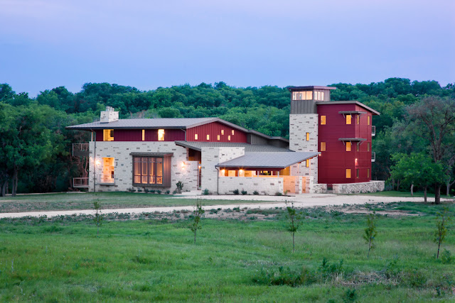 Picture of contemporary ranch house surrounded by the trees and green grass