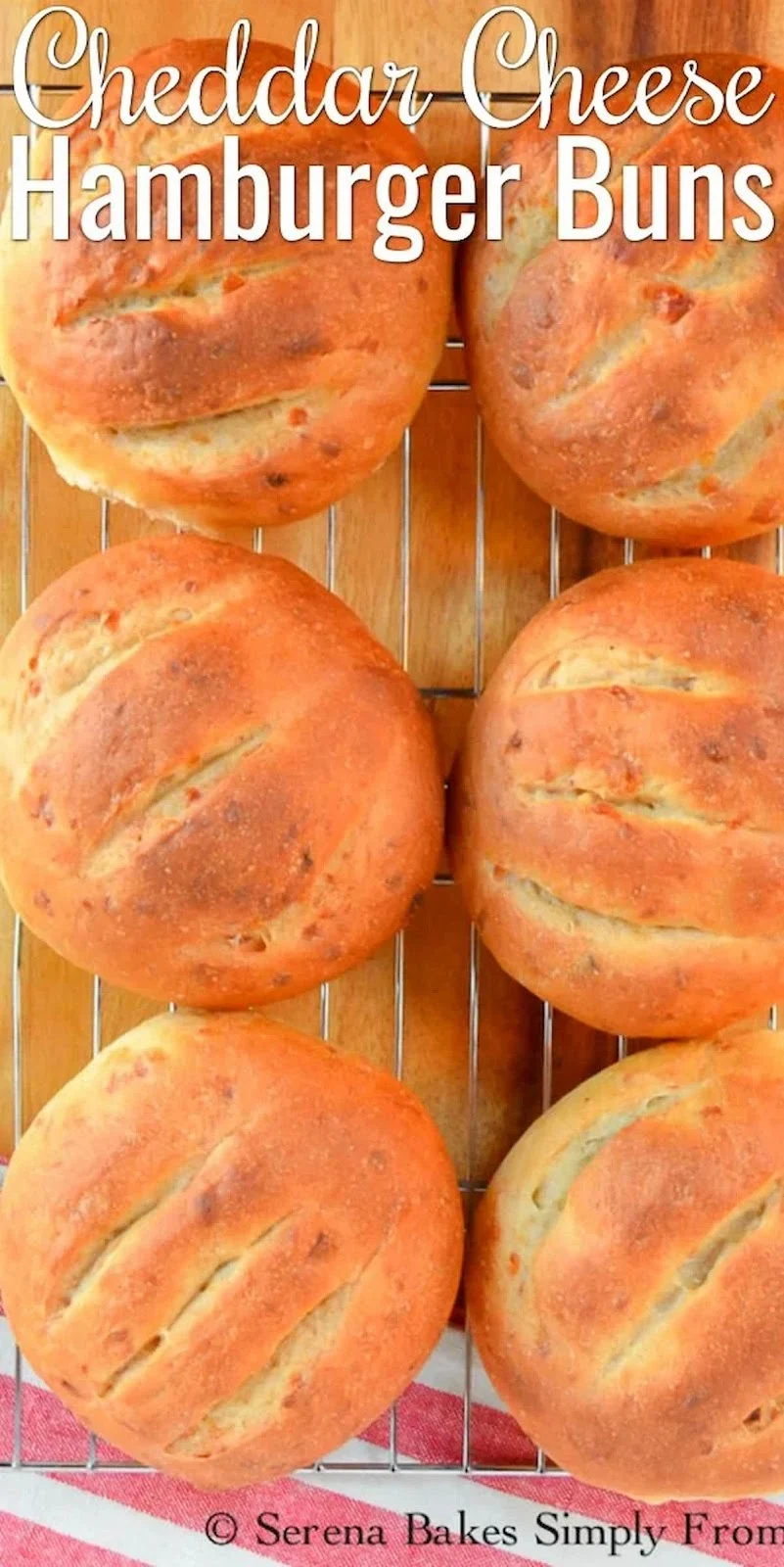 A down shot of Cheddar Cheese Hamburger Buns on a cooling rack with white text at the top of photo Cheddar Cheese Hamburger Buns.