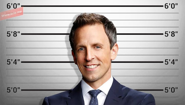 Seth Meyers standing in front of a height chart background