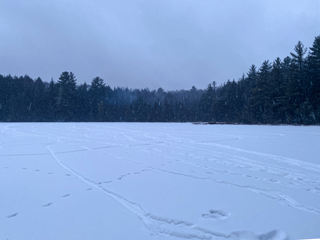 snow covered frozen lake with fat tire bike tracks