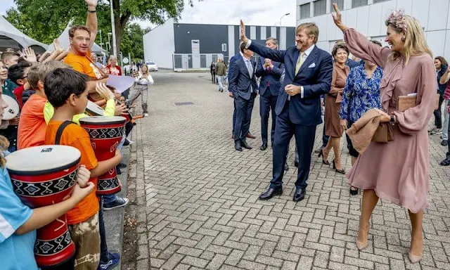 Queen Maxima wore a ruffled light pink silk dress by Natan. Berry Rutjes flower headband. Brown suede flat shoes